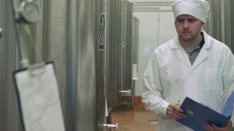 Worker takes readings at a brewery Stock Footage 158263559