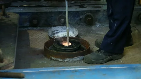Worker takes a sample of boiling metal Stock Footage 100578377
