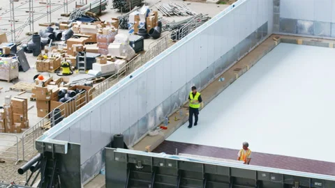 Worker takes tool to process white material for pool Stock Footage 231223744