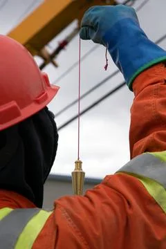 Worker taking measurement with a pendulum tool on installation of a telepho.. Stock Photos