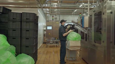Worker taking out empty bottles from a bag and putting them into a machine. Milk Stock Footage 152429902