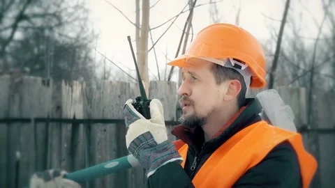Worker talking on the radio, in the hands holding a sledgehammer Stock Footage 72686891