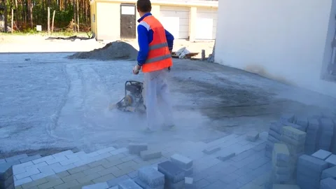 Worker tamping crushed stone with a vibrator1 Stock Footage 323924141