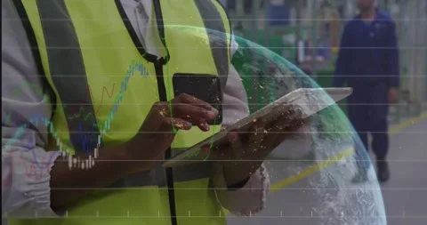 Worker tapping tablet in factory showing globe data graphs while team checking Stock Footage 325963469