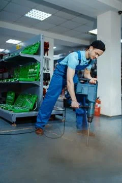 Worker testing big electric perforator, tool store Stock-Fotos