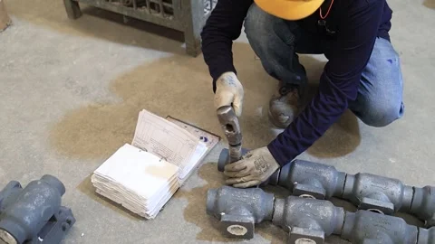 Worker is testing casting part strength with hammer Stock Footage 306109989