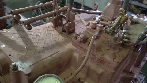 The worker is testing the gearbox of a large tractor. Repair of gearbox. Arrow Stock Footage 75325452