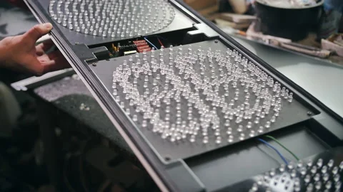 A worker tests a new traffic light at a factory. LEDs, energy-saving traffic Stock Footage 137567650