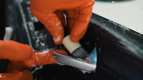 A worker thoroughly cleans the dashboard of the car with cleaning foam Stock Footage 146561948