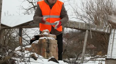 Worker throws bricks near the burned old house Stock Footage