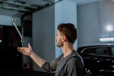 A worker throws a mechanical tool into a car service Stock Photos