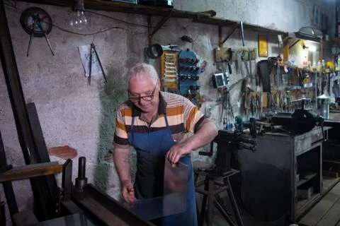 Worker is thrusting a metal sheet Stock Photos