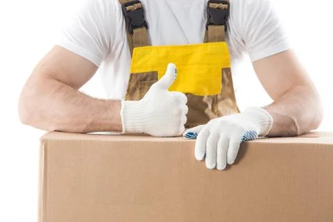 Worker with thumb up standing behind boxes with items isolated on white backg Stock Photos