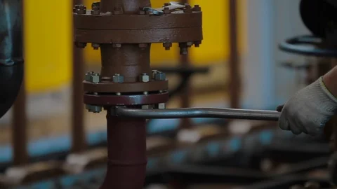 Worker tightens the bolt with a wrench. Worker assembles Oil and Gas equipment Vídeo Stock 127520499
