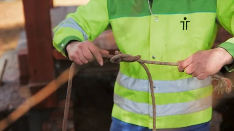 Worker tightens knot on a rope Stock Footage 97409742