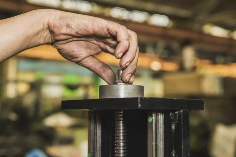 Worker tightens a nut on a machine with a dirty hand Stock Photos
