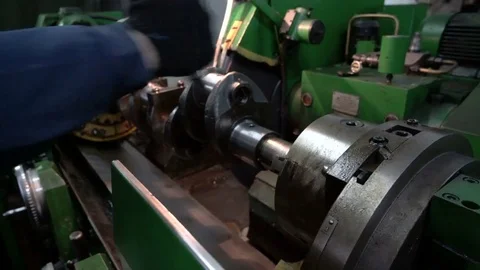 Worker tightens the part in the machine. Crankshaft grinding. Cnc machine starts Stock Footage 75236899