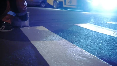 A worker tints a road marking of a transition against the background of a 스톡 동영상 97524232