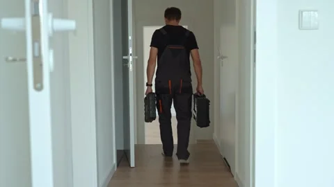 Worker with tools leaving room after renovation in modern home Stock Footage 310084003