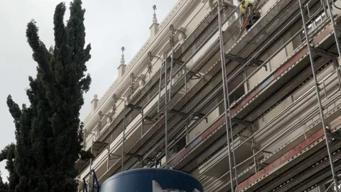 Worker on top of a scaffold is sending down piece of metal using a pulley. Stock Footage 122012164