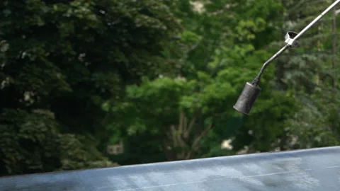 Worker With Torch Heating Bitumen Roll Roofing Felt. - close up Stock Footage 155136376