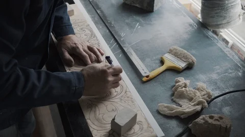 Worker traces lines with a stencil handle, the pattern is transferred to a marbl 스톡 동영상 99039293
