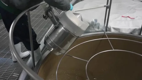 Worker Transferring Liquid Into a Large Fermentation Tank Vídeos de archivo 340010475