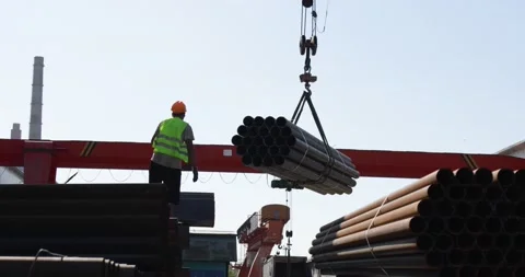 Worker transporting stack of metal pipes with gantry crane Stock Footage 205562932