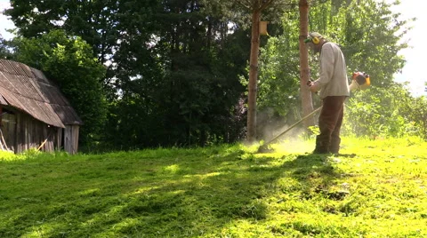 Worker trimming green grass with manually petrol lawn trimmer Stock Footage 41753307