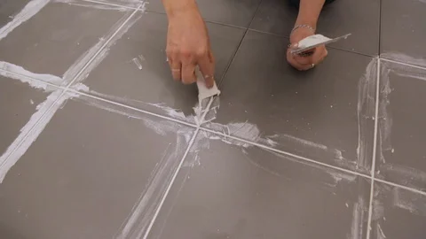 Worker troweling joints between tiles on floor Video stock 128416231