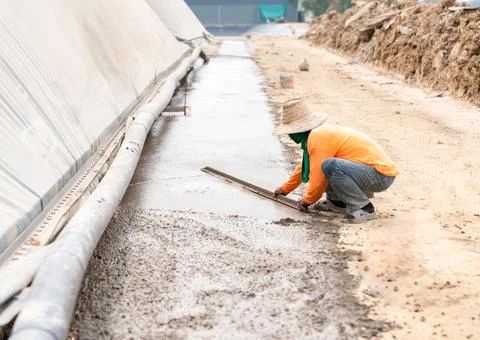 The worker is troweling the plaster to make it smooth. Stock Photos