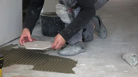 Worker turn on laser and lay hexagon floor tiles Stock Footage 151196923