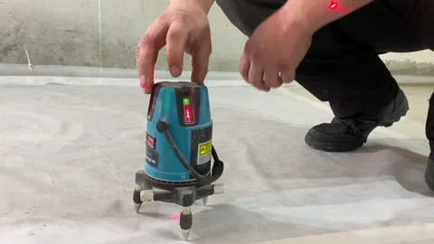 Worker turning on laser level device cement floor measuring markers renovation Stock-Footage 150175334