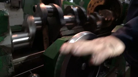 Worker turns the handle of the cnc machine. Crankshaft grinding. Repair work on Stock Footage 75237192