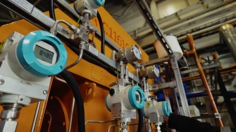 Worker turns lever on pressure meter at compressor at plant Stock Footage 117336884