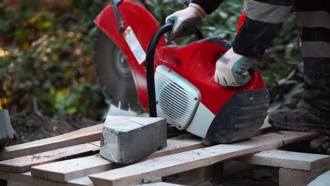 The worker turns on the tool after refueling the concrete cutter and flattens Stock Footage 120867142