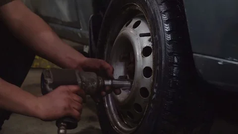 The worker twists the nuts on the wheel Video stock 84284397