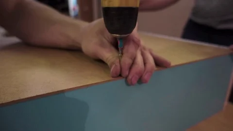 Worker twists the screw in the board. handyman Stock Footage 76915025