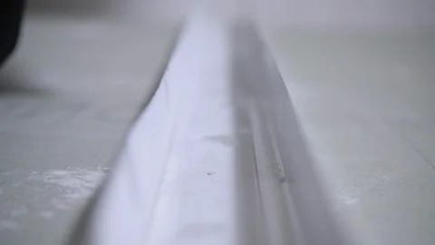 Worker twists screw into white drywall fixing bar closeup Stock Footage 108582762