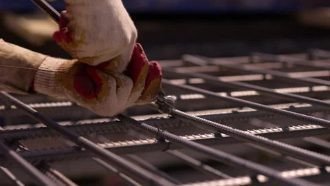 Worker tying reinforcing steel bars with wire during construction Stock-Footage 344471560