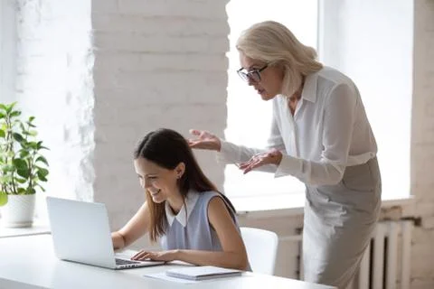 Worker typing on computer angry boss looking at laptop screen Foto stock