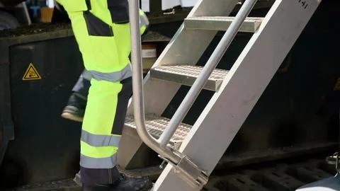 Worker in uniform goes up metal steps to technical ground Stock Footage 158164632