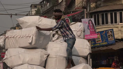 Worker unloading heavy parcels from a cargo truck in Kolkata bazaar, India Stock Footage 48785315