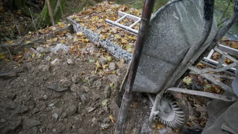 Worker unloads a wheelbarrow full of soil Stock Footage 158974359