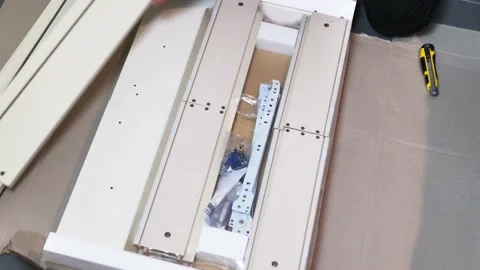 Worker unpacks packaging with drawers, close up. furniture assembly concept Stock Footage 148092806
