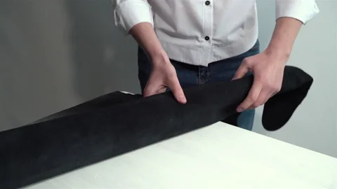 Worker unrolls and rolls up a roll of black leather 스톡 동영상 150227639