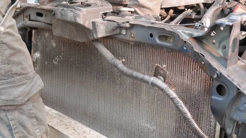 Worker unscrews engine coolant radiator of vehicle. Broken car after car Stock Footage 121114695