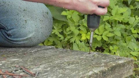 A worker unscrews a rusty self-tapping screw from an old board. Stock Footage 158893797