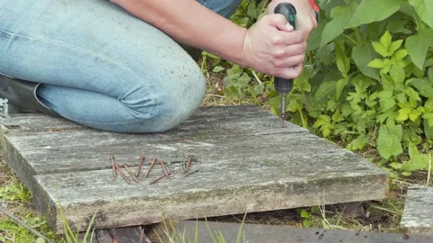 A worker unscrews a rusty self-tapping screw from an old board. Stock Footage 158893933