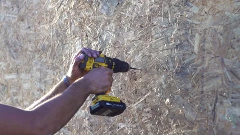 A worker unscrews a screw into a wall 4K Stock Footage 294047301